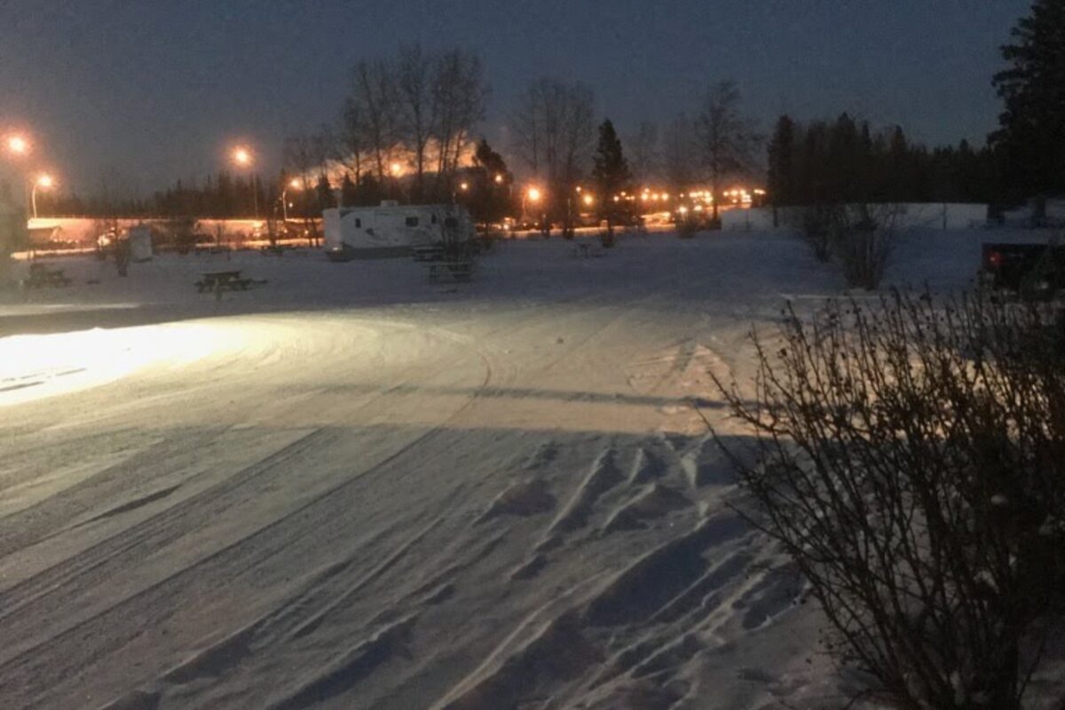Edson RV Park in winter with snow-covered grounds and warm lights in the distance